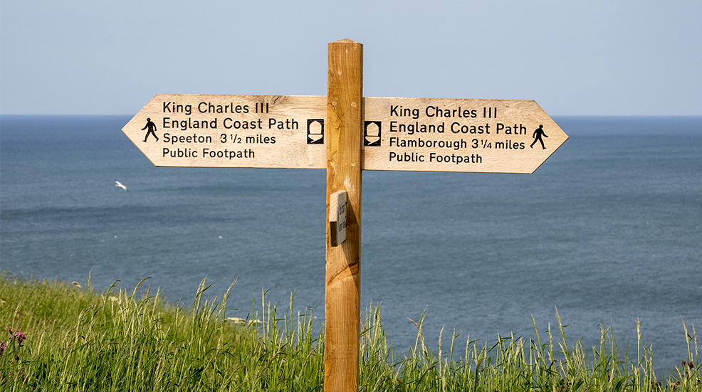 A sign for the England Coast Path at Bempton Cliffs in Yorkshire, UK.